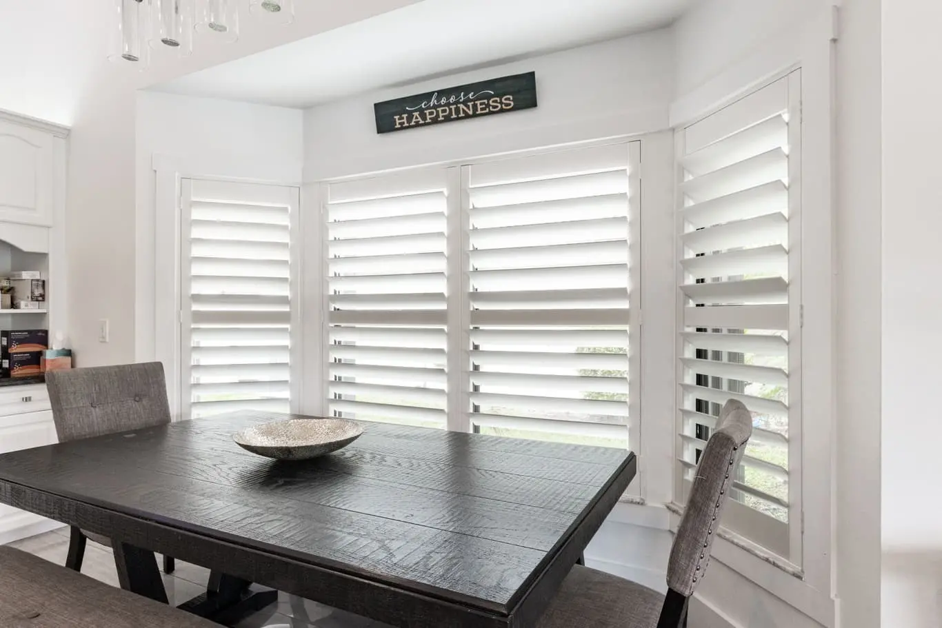 Custom plantation shutters in a bright, sunlit dining room