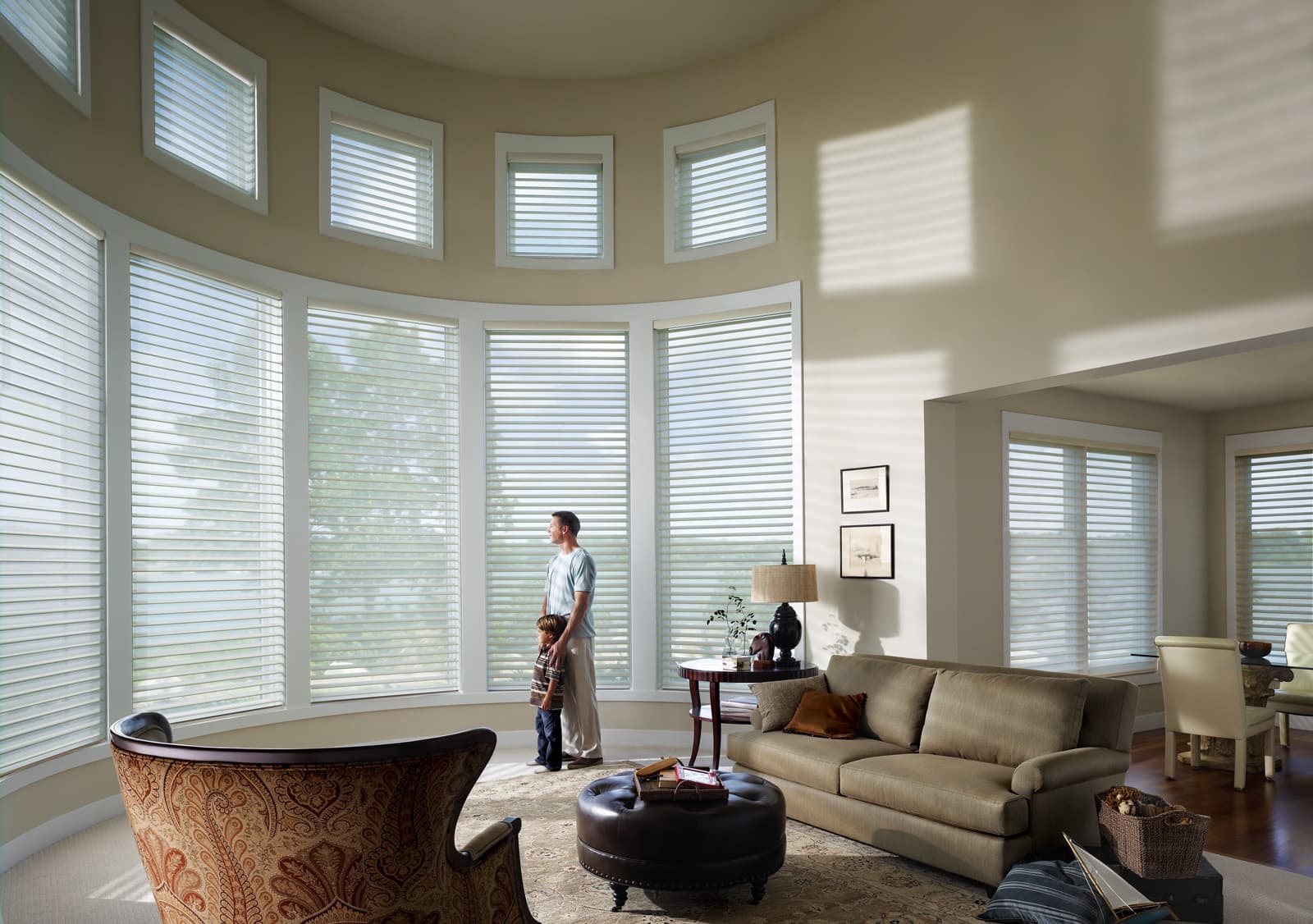 Sheer shades on tall windows with a father and young son